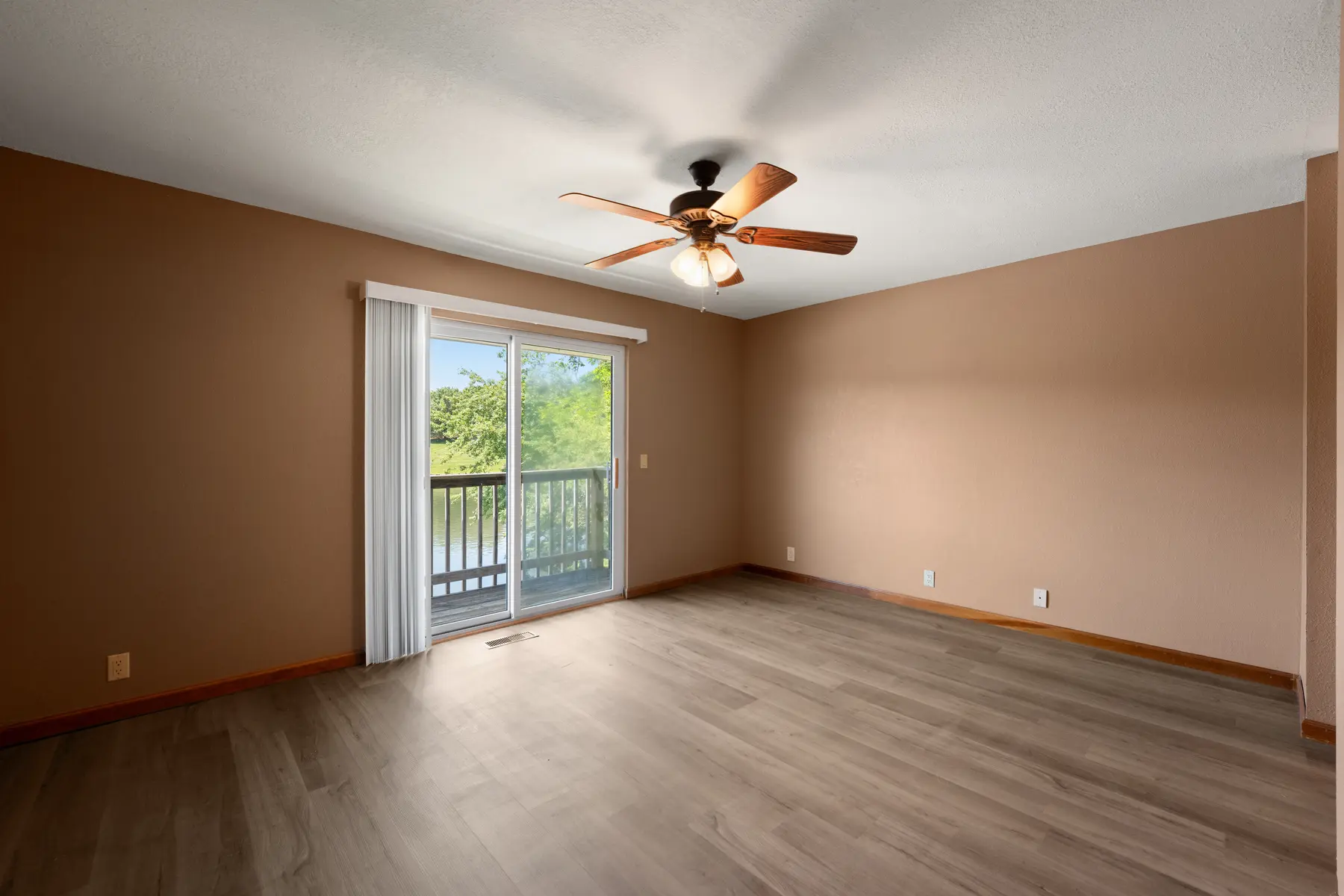 Primary bedroom with private lake-facing balcony in Unit 101