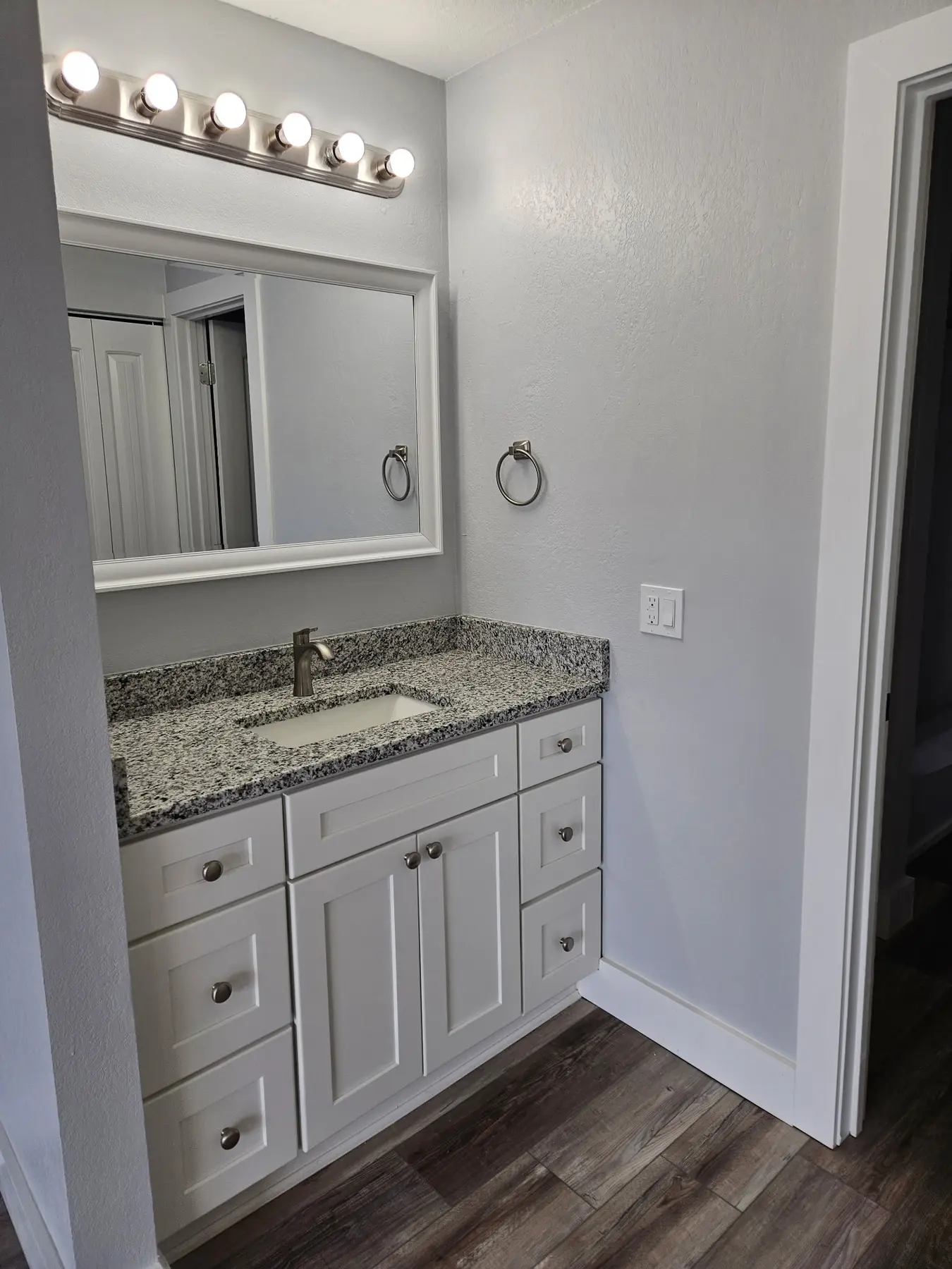 Full bathroom vanity with granite countertop in Unit 103