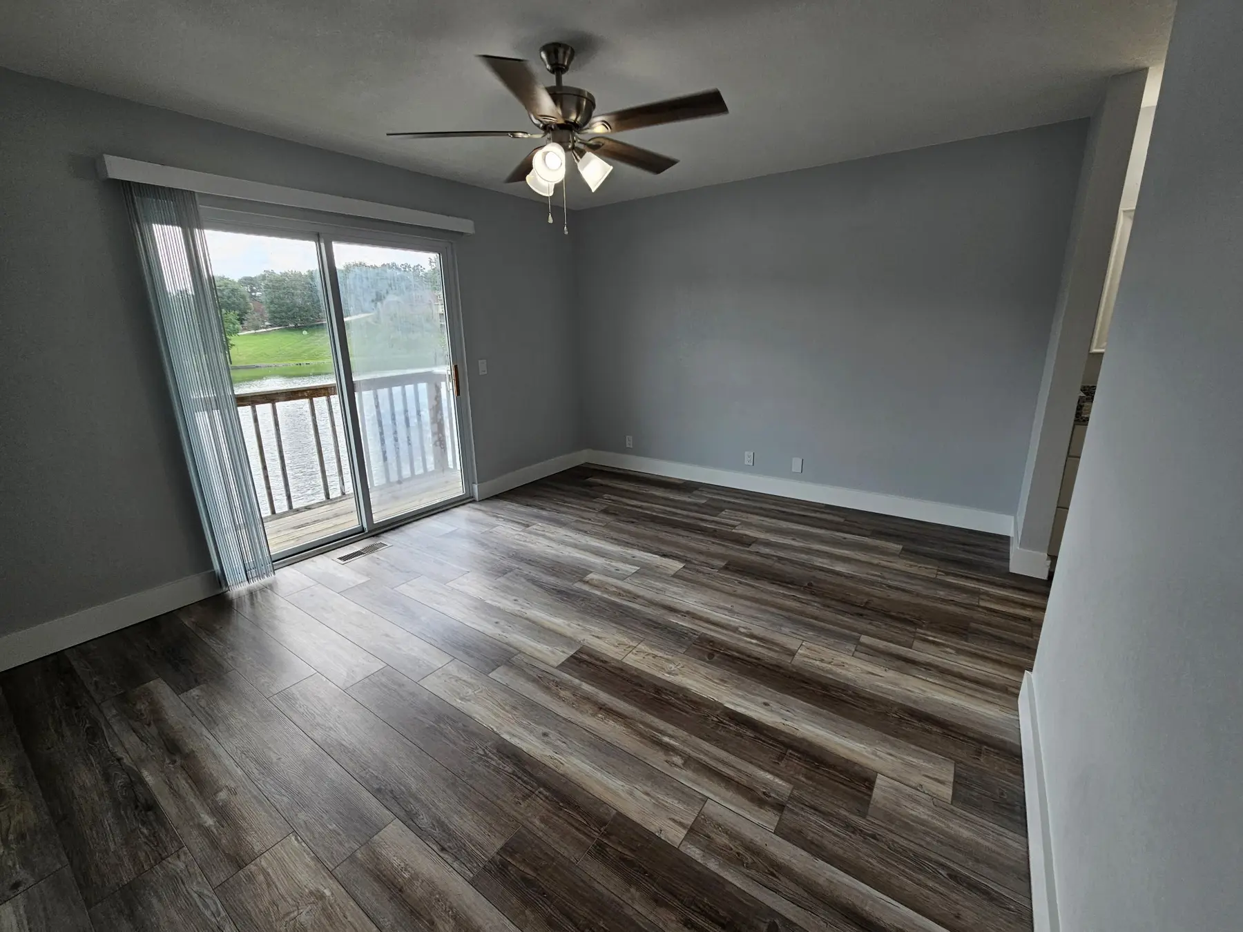 Primary bedroom with private lake-facing balcony in Unit 103