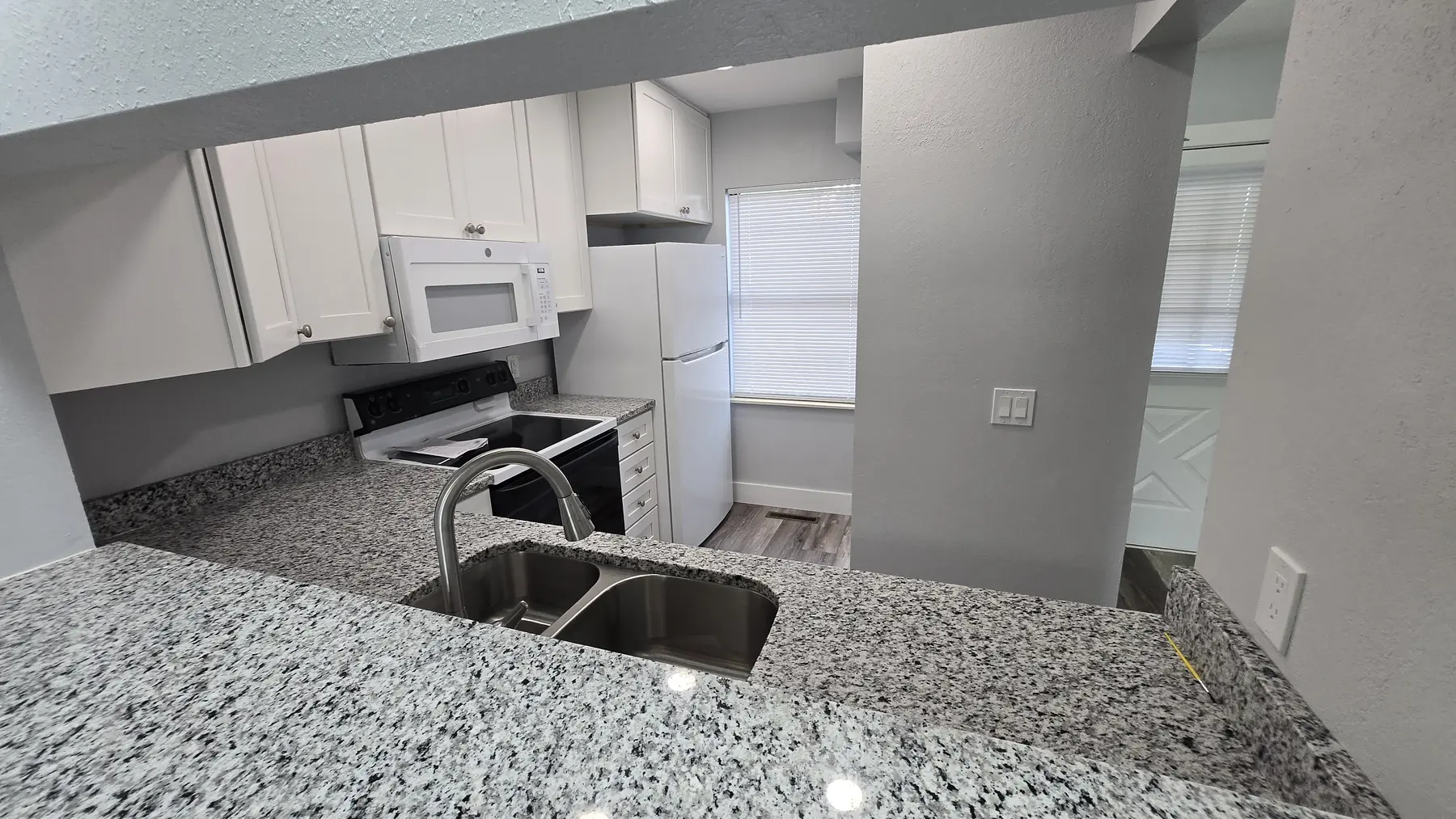 Granite kitchen peninsula and sink in Unit 103