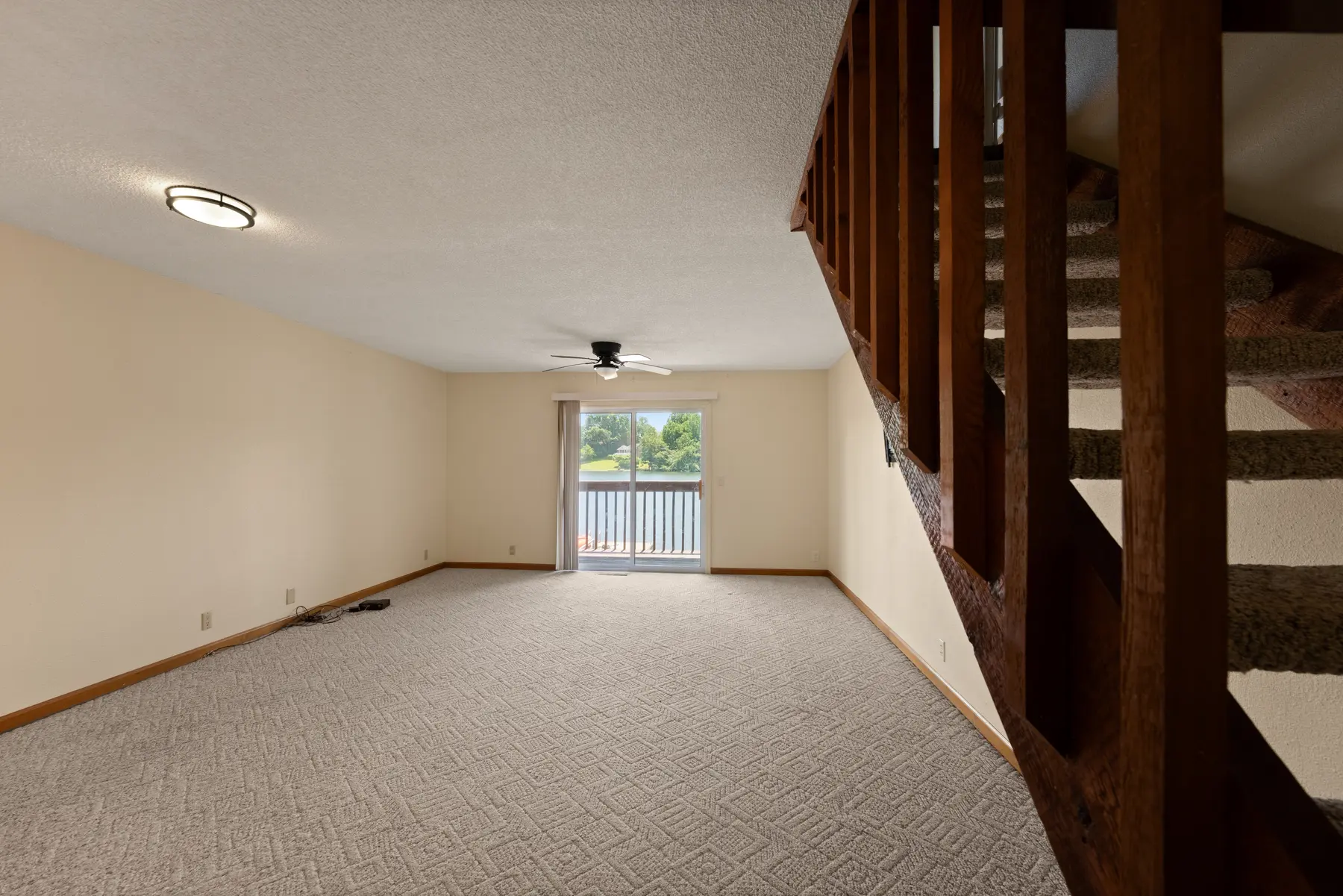Lake-facing living room with staircase in Unit 102
