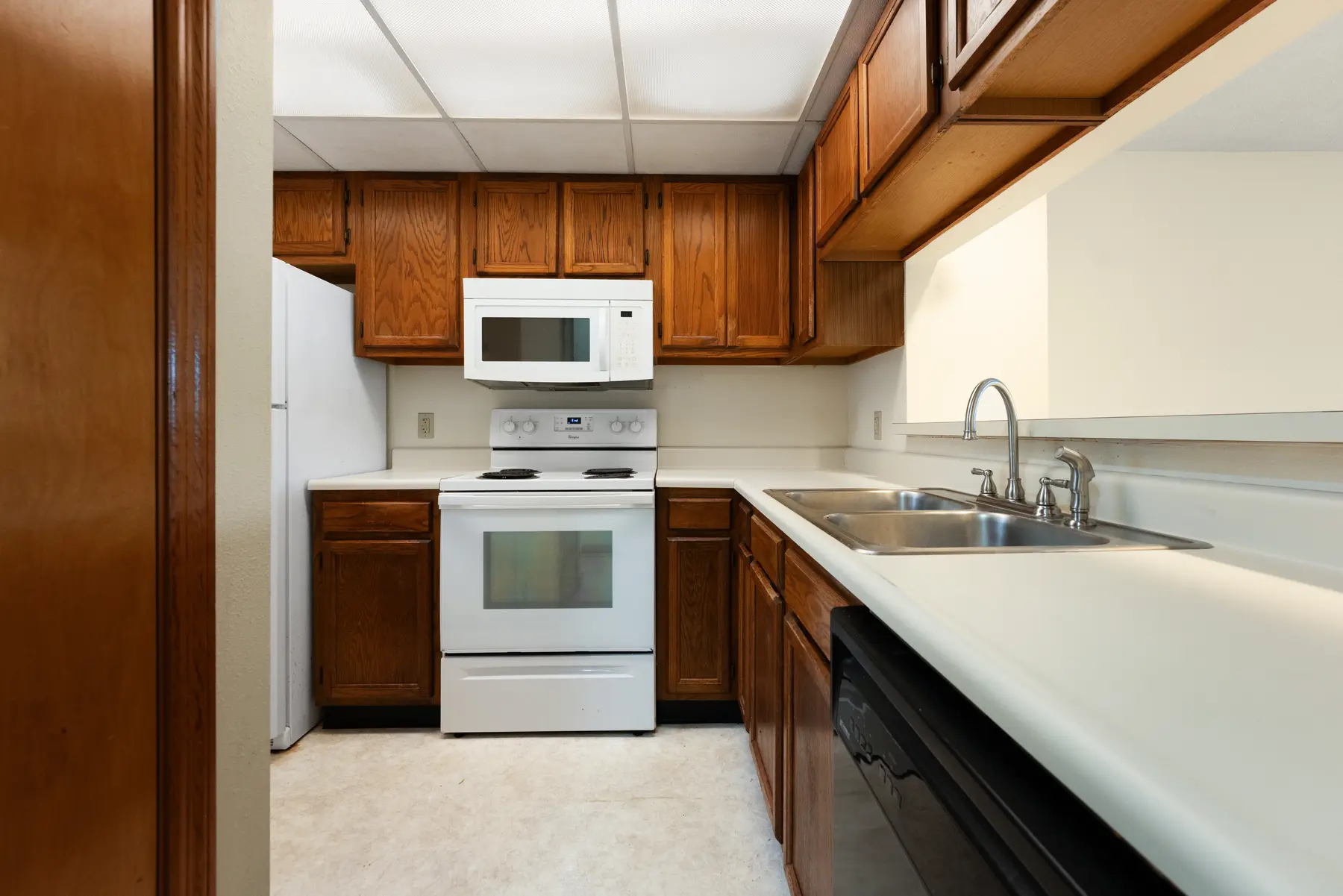 Kitchen with wood cabinets and white appliances in Unit 102