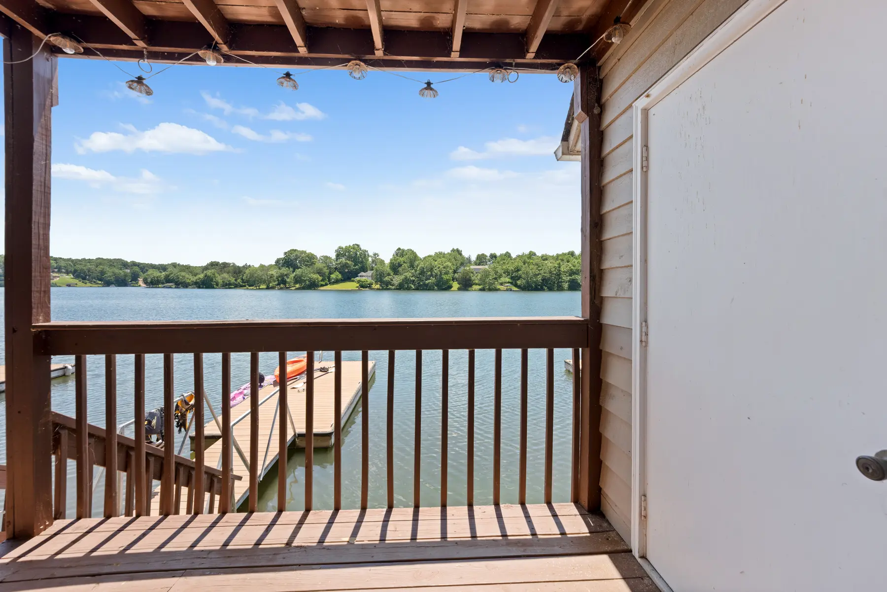 Covered balcony with a direct view of Lake Holiday in Unit 102