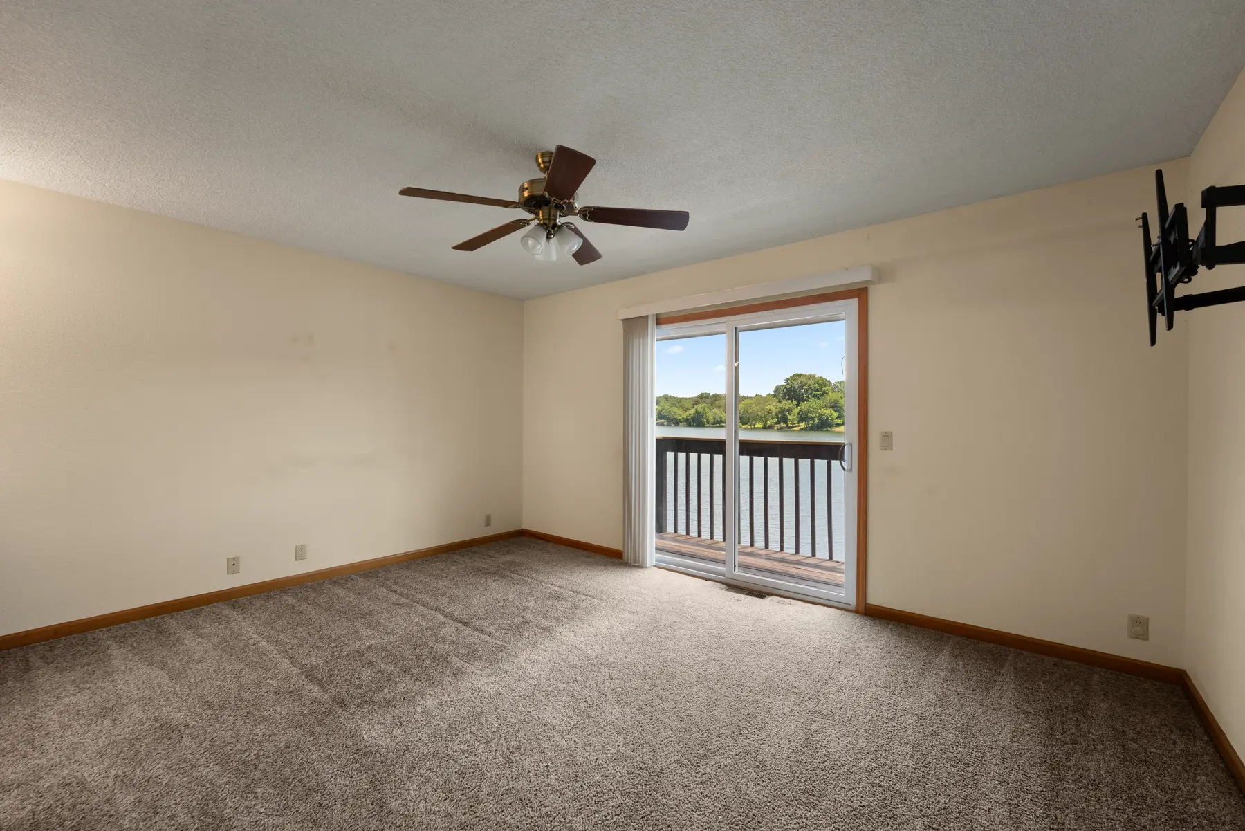 Primary bedroom with lake-facing balcony access in Unit 102