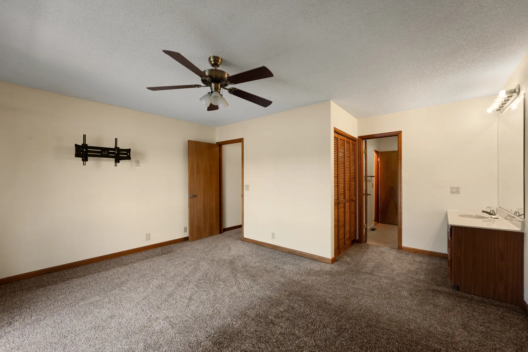 Primary bedroom viewed toward the bathroom and hallway in Unit 102