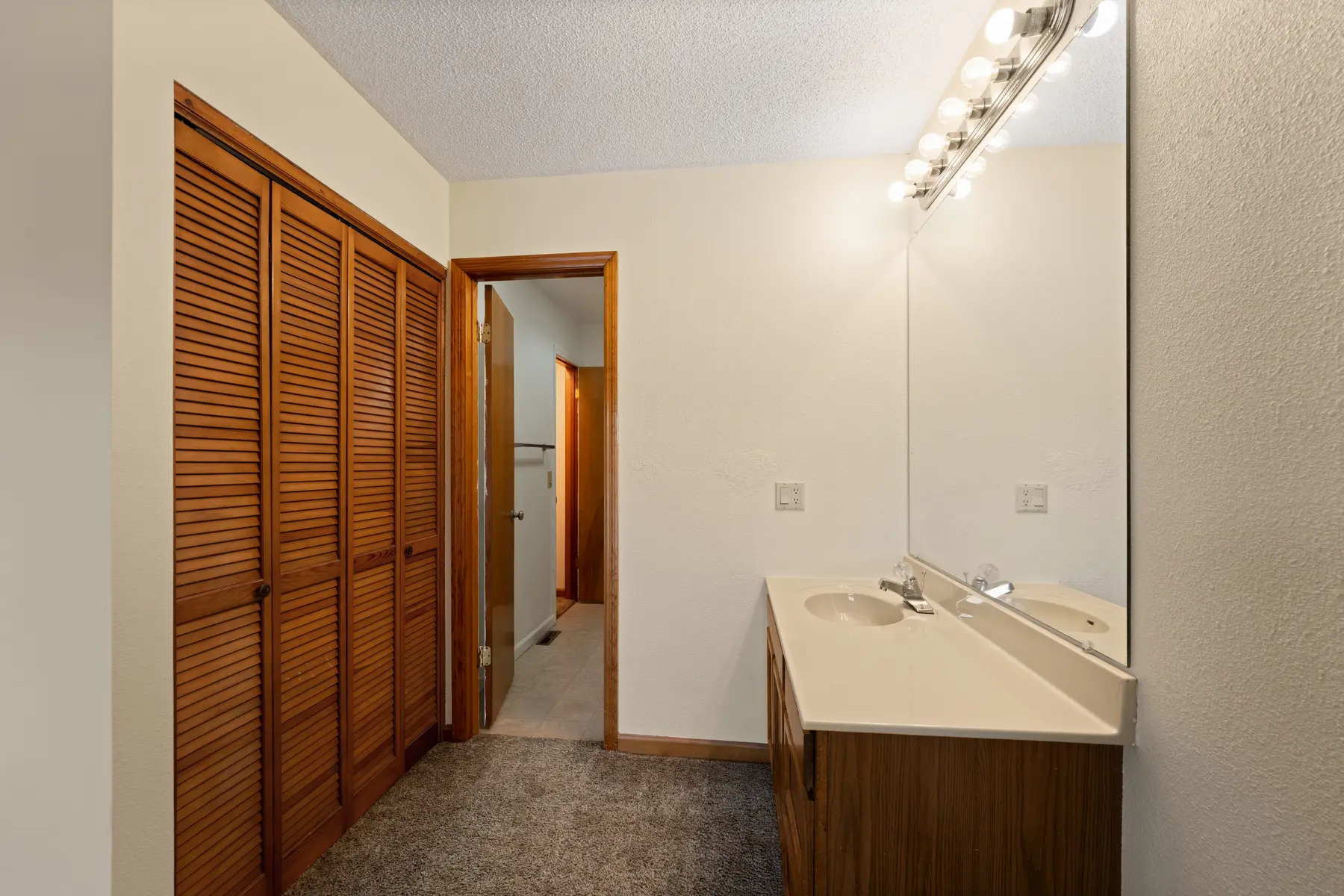 Full bathroom vanity and linen closet in Unit 102